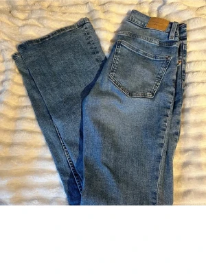 Blå bootcut jeans från Levi's - Snygga blå bootcut jeans från gina med klassisk femficksdesign och normalhög midja. Jeansen har en ljus tvätt och är tillverkade i denim med en skön känsla. Perfekta för dig som gillar en avslappnad men trendig look.