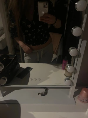 Svart blommig blus från Vero Moda - Snygg svart blus från Vero Moda med vita blommor och v-ringning. Blusen har långa ärmar och knappar framtill. Figurnära passform och lätt puff vid axlarna ger en trendig look. Perfekt att styla med jeans eller kjol för en cool outfit.