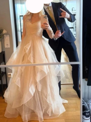 Balklänning med volanger  - kollar intresset på min eleganta beigea långklänning med tunna axelband och v-ringad urringning. Klänningen har flera lager av volanger i kjolen och en slits på sidan som ger en extra snygg touch. Perfekt för balen! Det är bara att skriva om ni har fler frågor, den enda defekten är att den kan vara är lite smutsig längst ner men inget som riktigt syns. Bara använd vid ett tillfälle. NYPRIS INKL FRAKT TILL SVERIGE: 2200kr