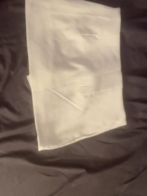 Vit kortkjol i bomull - Säljer en enkel och stilren vit kortkjol i mjukt bomullstyg. Kjolen har en rak passform och är perfekt för dig som gillar minimalistisk stil. Inga synliga detaljer eller mönster, bara clean och fräsch look.