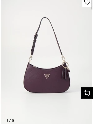 Noelle top zip shoulder bag - Säljer denna superfina väska från guess i färgen aubergine som just nu är slutsåld. Väskan är i väldigt bra skick då jag nästan aldrig använt den. Nypris 1499kr