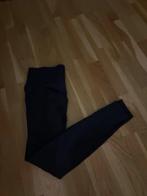 Svarta höga leggings - Säljer ett par svarta leggings med hög midja och smal passform. De är stretchiga och sitter tight längs benen, perfekta till oversized tröjor eller hoodies. Materialet känns mjukt och följsamt, vilket gör dem riktigt bekväma att bära hela dagen.