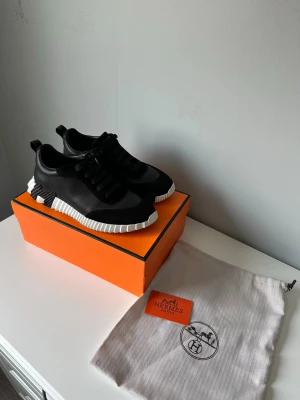 H skor svart vit - Snygga svarta sneakers från H  med coola detaljer och kontrasterande vit räfflad sula. Skorna har en mix av läder och mocka, klassisk snörning och modern design. Perfekta för dig som gillar exklusiva och trendiga sneakers.