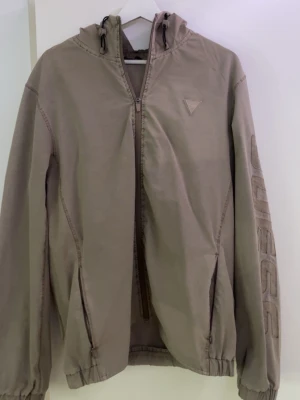 En guess windbreaker jacka - En guess jacka i storlek L en unik beige färg, den är tunn och perfekt för våren/sommaren