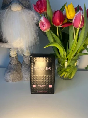 Valentino Born In Roma Intense EdP - Valentino Born In Roma Intense Eau de Parfum i en snygg svart kartong med pyramidmönster och rosa detaljer. Doften är elegant och modern, perfekt för dig som vill sticka ut. Flaskan rymmer 100 ml och är en riktig statement-parfym från ett ikoniskt modehus.