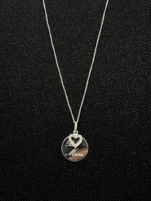Äkta Silverhalsband med hjärthänge - Snyggt äkta silver halsband med ett runt hänge där det står 'Best Mum' och ett gnistrande hjärta dekorerat med små stenar. Perfekt present till mamma och ger en personlig touch till din stil. Kedjan är tunn och elegant. Helt ny!
