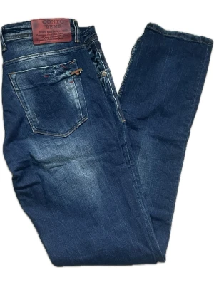 Blå jeans från Conto Bene - Snygga blå jeans från Conto Bene med klassisk femficksdesign och läderpatch bak i midjan. Jeansen har en normal passform och är tillverkade i slitstark bomull. Fina detaljer med kontrastsömmar och diskret tvättad look.