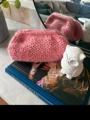 Rosa virkad necessär - Söt rosa necessär i virkat garn med blommigt mönster. Perfekt för småprylar eller smink. Mjuk och flexibel form, utan synligt märke. Passar dig som gillar handgjorda accessoarer och vill ha något unikt i väskan.