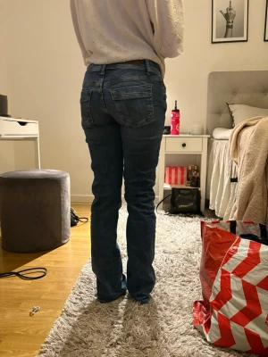 Ltb jeans💖💖 - Säljer ett par klassiska blå bootcut jeans med fem fickor och normalhög midja. Jeansen har en lätt tvättad look och stängs med knapp och dragkedja. Perfekta för en avslappnad och trendig stil.
