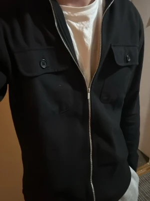 Svart overshirt med dragkedja - Tjena säljer denna svarta overshirten pga att jag redan har 2 andra. Skriv gärna om ni har funderingar eller frågor