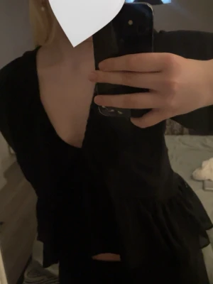 Svart topp med öppen rygg - Snygg svart omlottopp med djup v-ringning och öppen rygg😽 Tunn och bekväm, perfekt till våren/sommaren. Storlek XL men skulle säga att den sitter mer som en M🖤
