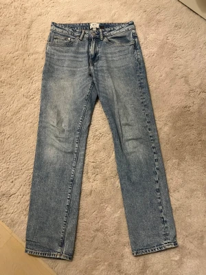 Ljusblå raka jeans från H&M - Säljer ett par ljusblå jeans från H&M med rak passform och klassisk femficksdesign. Jeansen har en snygg tvättad look och är tillverkade i bomull. Perfekta för en avslappnad och trendig stil.            Oanvända Jeans som du kan få för en billig peng, skön färg ändå. Köp dem gärna tillsammans med nått annat jag säljer 29/32 i storlek.