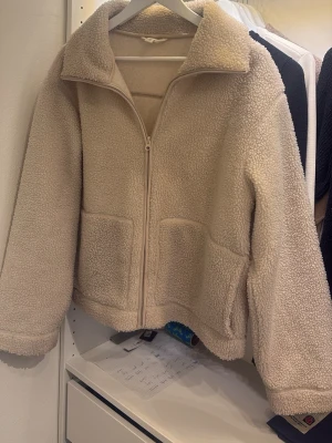 Beige teddyjacka med dragkedja - Mysig beige teddyjacka med dragkedja framtill och två stora fickor. Storlek L men passar mer som en M. Perfekt för kallare kvällar, säljer då den inte används lika mycket🥹❣️skriv för bild på eller för att diskutera pris!!