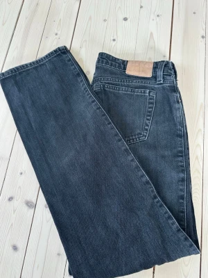 Svarta raka jeans med låg midja weekday - Säljer ett par svarta jeans med rak passform och låg midja. Jeansen har klassisk femficksdesign och är tillverkade i kraftig denim. Perfekta för en avslappnad och trendig look. Från weekday i modellen ”arrow”, storlek w26 l32. Mycket fint skick! Nypris: 590kr