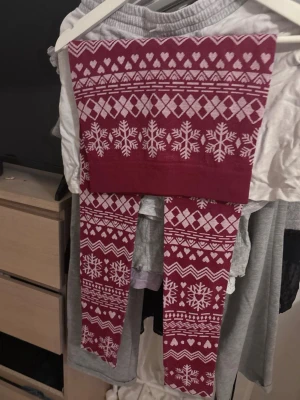 Röda leggings med vintermönster - Röda leggings med vita snöflingor, hjärtan och geometriska mönster. Perfekta som underställ eller bara så!