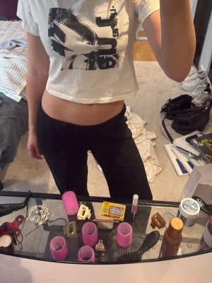 Vit croppad t-shirt med tryck - Säljer en vit croppad t-shirt med svart grafiskt tryck framtill. T-shirten har korta ärmar och rund halsringning. Perfekt för dig som gillar en avslappnad och trendig stil.