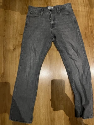 Grå raka jeans från Weekday - Snygga grå jeans från Jack & Jones med rak passform och klassisk femficksdesign. Jeansen har knappgylf och är tillverkade i denim med en lätt tvättad look. Perfekta för en avslappnad och trendig stil.