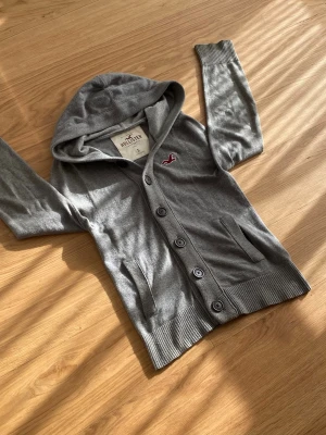 Hollister cardigan  - Säljer en riktig snygg Hollister cardigan i färgen grå. Denna är väldigt eftertraktad. Skicket är 10/10. Storleken är S. Priset är 599kr men kan sänkas. 