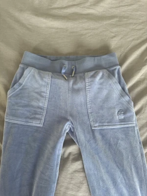 Ljusblåa mjukisbyxor Juicy Couture - Säljer också både byxor och tröja (och i sett för billigare) i beigt och svart!! Ett par ljusblåa mjukisbyxor från Juicy Couture. Storlek XXS.