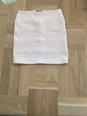 En ljus rosa kjol från Topshop som är i nyskick  - En ljus rosa tajt kjol i bekvämt material.Den är i nytt skick och är från topshop. I butik är priset upp till 500kr.