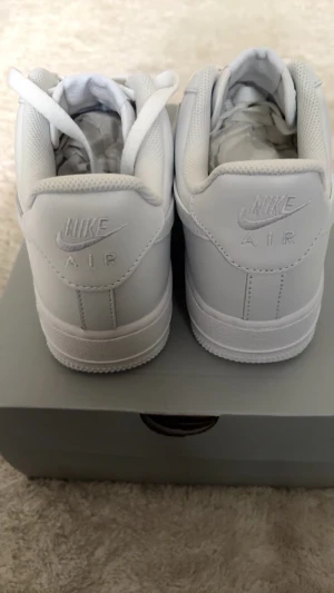 Nike Air Force 1 vita sneakers - Klassiska helvita Nike Air Force 1 sneakers med lågt skaft. Skorna har ovandel i slätt läder, vita skosnören och diskret Nike-logga på hälen och innersulan. Perfekta för dig som gillar en clean och tidlös look. ❗️PRIS GÅR ATT DISKUTERAS❗️