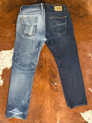 Nudie jeans SharpBengt DryBrownSelvage - Tjena! Säljer dessa vintage nudie jeans i modellen SharpBengt DryBrownSelvage: Byxorna är i storlek W33/L32 och är i fint skick: Hör av dig vid funderingar!🙌  Only ONE pair of jeans is for sale – the DARK BLUE ones. The light blue jeans in the photos are my private pair, just to show how this denim could fade over time since that is the whole point with dry jeans. You are buying the dark blue jeans only