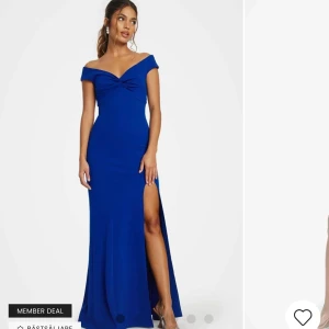 Blå långklänning med twistdetalj - Elegant blå långklänning med offshoulder-design och en snygg twistdetalj framtill. Klänningen har en hög slits som ger en sofistikerad touch. Perfekt för speciella tillfällen. 