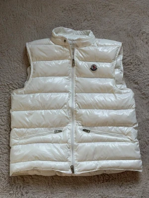 Moncler gui gilett väst  - En moncler väst i mycket fint skick i vit färg. Storlek S men sitter som m, tillkommer med kvitto och tags.