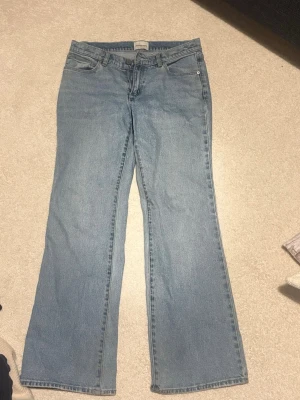 Ljusblå bootcut jeans från Abrand - Säljer ett par ljusblå bootcut jeans från Abrand Jeans. Klassisk femficksmodell med dragkedja och knapp. Jeansen har en avslappnad passform och är tillverkade i denim med lätt tvättad look. Perfekta för en casual och trendig stil.