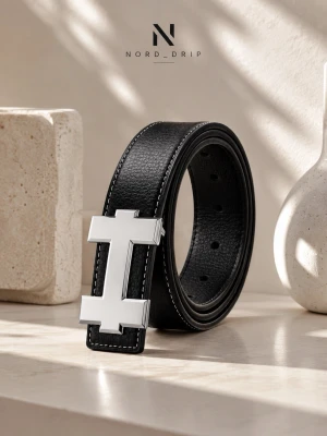 H-Bälte - Stilrent svart bälte i skinn med ett stort, silverfärgat H-format spänne. Bältet har vit kontrastsöm längs kanterna och en klassisk design som passar till många olika outfits.