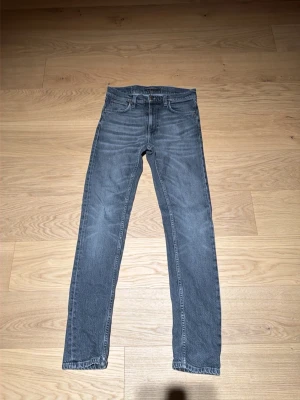 Grå smala jeans med fem fickor - Snygga grå jeans i slim fit-modell med klassisk femficksdesign och normal midja. Jeansen har dragkedjegylf och raka ben. Perfekta för en avslappnad och trendig stil. Har därimot nån fläck på framsidan men fortfarande riktigt bra skick. Läng på byxorna är 30