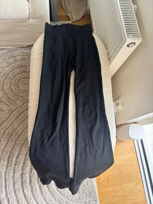 Svarta bootcut leggings från Aimn - Säljer ett par svarta leggings med bootcut-modell och hög midja. De är stretchiga och mjuka, perfekta för en avslappnad och trendig look. Materialet känns som bomullsmix med lite elastan för extra komfort. 