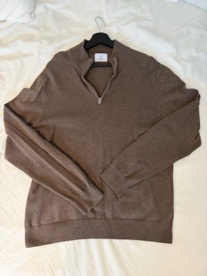 Brun halvzip tröja från Bläck - Snygg brun tröja från Bläck med halvzip. Tillverkad i mjukt material. Perfekt för lager på lager och enkel att matcha med jeans eller chinos.