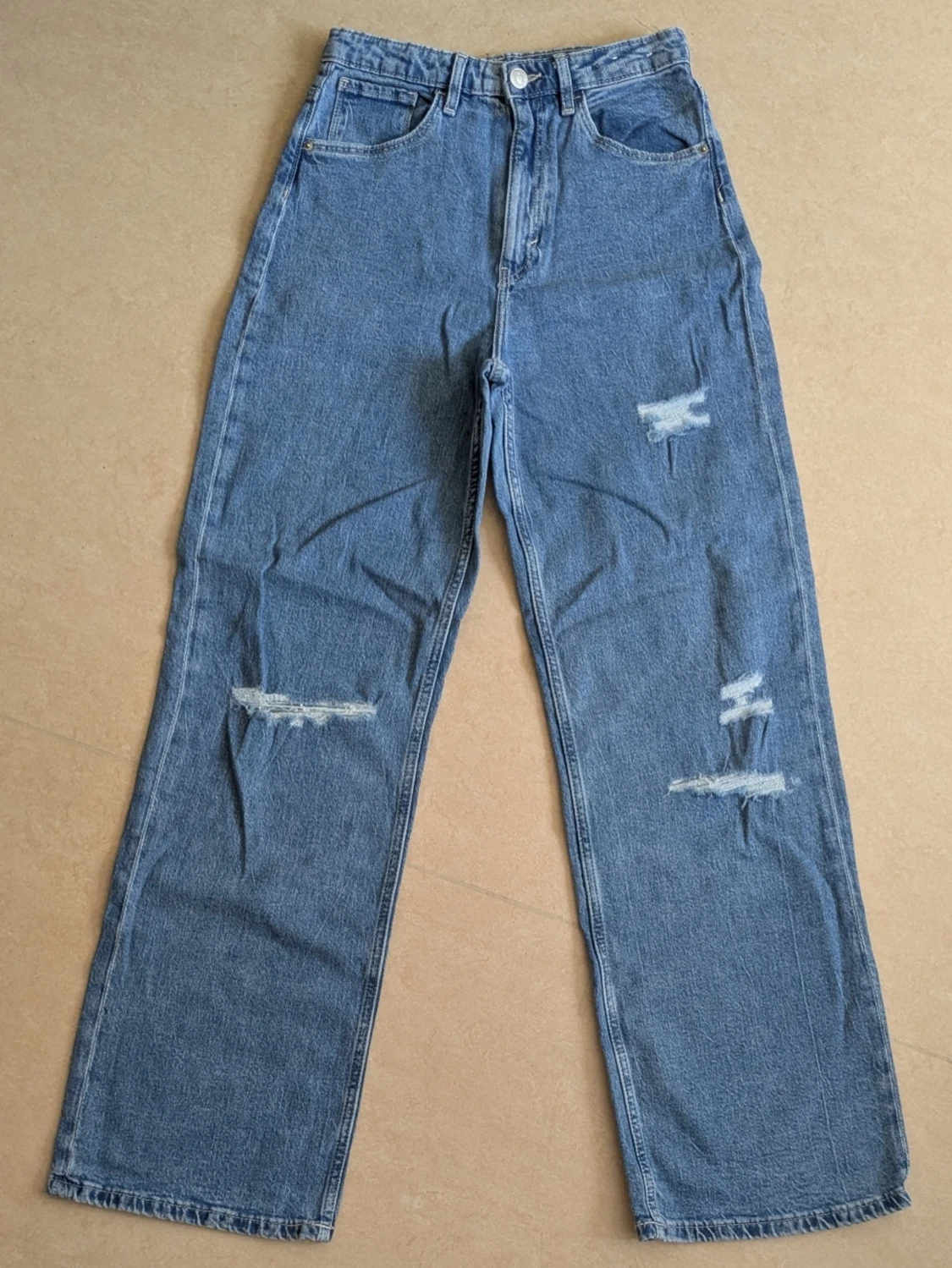 Blå raka jeans med slitningar
