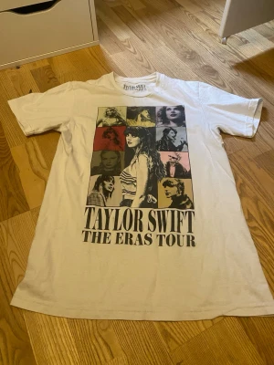 Taylor Swift The Eras Tour t-shirt - Vit t-shirt från Taylor Swift The Eras Tour 2023-2024 med tryck av olika bilder på Taylor Swift i färgade rutor framtill. Klassisk passform med rund hals och korta ärmar. Tillverkad i 100% bomull, perfekt för fans av Taylor Swift. Priset kan diskuteras🫶🏻