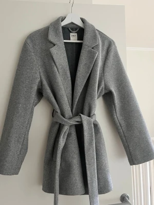 Grå kappa med bälte  - Grå kappa från ONLY med bälte i midjan. Väldigt fin passform. Storlek: M Fint skick. Jag är 185 cm.  Pris: 250 kr, har du förslag på pris kom med prisförslag.  Skickar inom 1 dag☺️✨