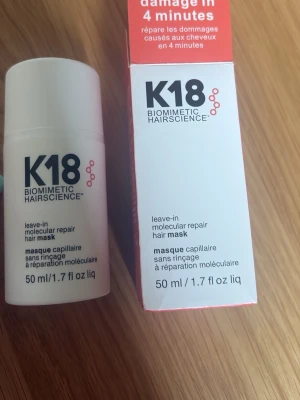 K18 leave-in hårmask 50 ml - K18 Biomimetic Hairscience leave-in molecular repair hair mask, 50 ml. En innovativ hårmask som reparerar skadat hår på molekylär nivå. Kommer i vit plastflaska med svart text och tillhörande förpackning i vitt och rött.