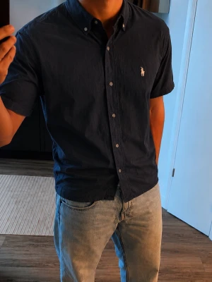 Polo Ralph Lauren Skjorta - Mörkblå, Kortärmad Ralph Lauren skjorta                                                       Märkt som storlek L, men har krympt och passar M