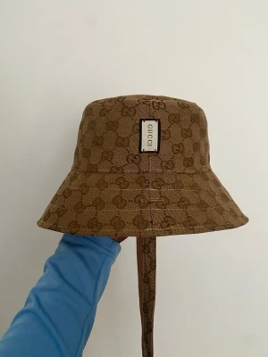Brun Bucket Hat Reversible  - Säljer en brun bucket hat som kommer i topp skick och passar perfekt nu till sommaren. Jag tar gärna emot bud och kom också med frågor om du undrar något.