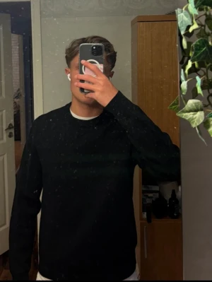 Svart uniqlo sweatshirt herr - En enkel svart sweatshirt med rund hals och långa ärmar. Tröjan har en klassisk passform och är tillverkad i ett mjukt material som passar perfekt till jeans eller shorts. Inga synliga loggor eller tryck, vilket gör den lätt att matcha med olika stilar.