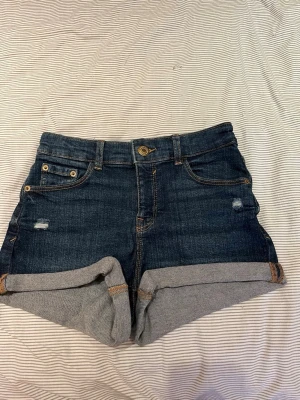 Jeansshorts - Mörkblå denimshorts från Pull & Bear med femficksdesign och uppvikta benslut. Perfekta till sommaren!☀️🌸Mid-waist
