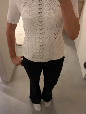 Vit stickad topp med kort ärm - Snygg vit stickad topp med korta ärmar och ett detaljerat mönster framtill. Toppen har en kroppsnära passform🌸