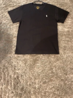 Polo Ralph Lauren T-shirt Svart  - Svart T-shirt från Polo Ralph Lauren. Storlek M passar som dess storlek. Funkar till båda könen.  Skickas samma dag. Äkta och nytt.