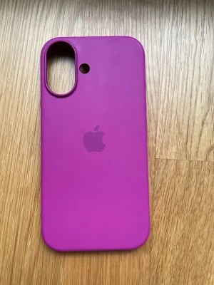Rosa (lite lila ton) silikonskal till iPhone - Snyggt lila mobilskal från Apple i mjukt silikonmaterial. Skalet har en stilren design med Apple-loggan på baksidan och stora utskärningar för kamera och blixt. Perfekt för dig som vill ge din iPhone ett färgglatt och modernt utseende. nytvättad och orginal från apple