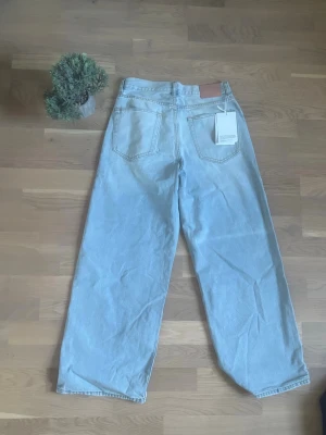  Acne Studios jeans - Säljer ett par ljusblå jeans från Acne Studios med raka ben och klassisk femficksdesign. Jeansen har en snygg läderpatch bak och är tillverkade i bomullsdenim. Perfekt för dig som gillar stilrena och trendiga jeans. Storlek S - passar mig bra i midjan och jag har W30-32, längden lite för lång för mig och jag är 172