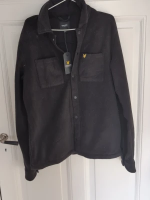 Helt ny Svart overshirt från Lyle & Scott - Passar mellan 170 - 180 15/16 år. HELT NY OANVÄND! 