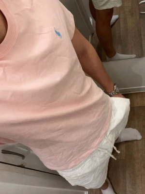 Rosa tshirt från Polo Ralph Lauren (Helt ny / Oanvänd) - Säljer en ljusrosa t-shirt från Ralph Lauren med klassisk blå logga broderad på bröstet. T-shirten har rund halsringning och är kortärmad. Tillverkad i mjuk bomull för en skön och avslappnad stil. Storlek Medium men passar mer som small. Snabb Leverans!