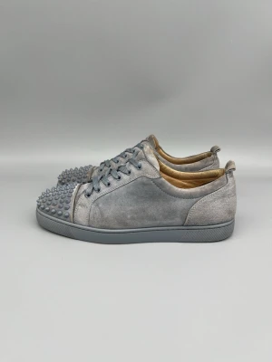 Christian Louboutin Louis Junior Spikes Sneaker Grey - • The shoes have been gently used and are in good condition  • Size: 44 (fits 44.5–45)  • Color: Grey  • Retail price: 9500 SEK / 795€  • No accessories included