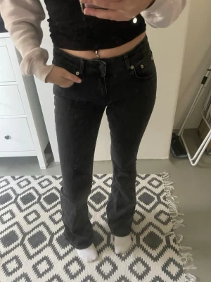 Svarta bootcut jeans med hög midja - Säljer ett par svarta bootcut jeans. Jeansen är i en tvätt som kan upplevas svart/mörkgrå. Använda fåtal gånger. Full längd, för jämförelse så är jag 164 