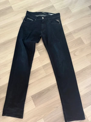 Mörkblå jeans från Replay - Snygga mörkblå jeans från Replay med raka ben och klassisk femficksdesign. Jeansen har detaljerade sömmar och en liten Replay-logga vid fickan. Perfekta för dig som gillar stilrena och tidlösa jeans. Knappt användna, tror även de har en sjuk potential med fades och sånt om ni gillar det! Ställ gärna frågor 